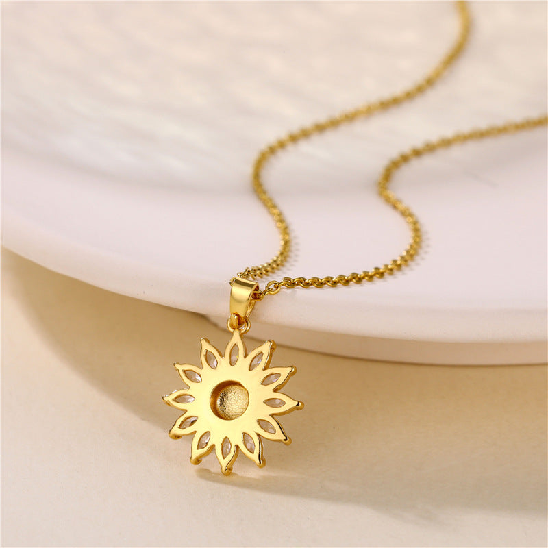 Gold sunflower pendant necklace on a light beige background