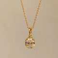 Gold necklace with a diamond pendant on a beige background