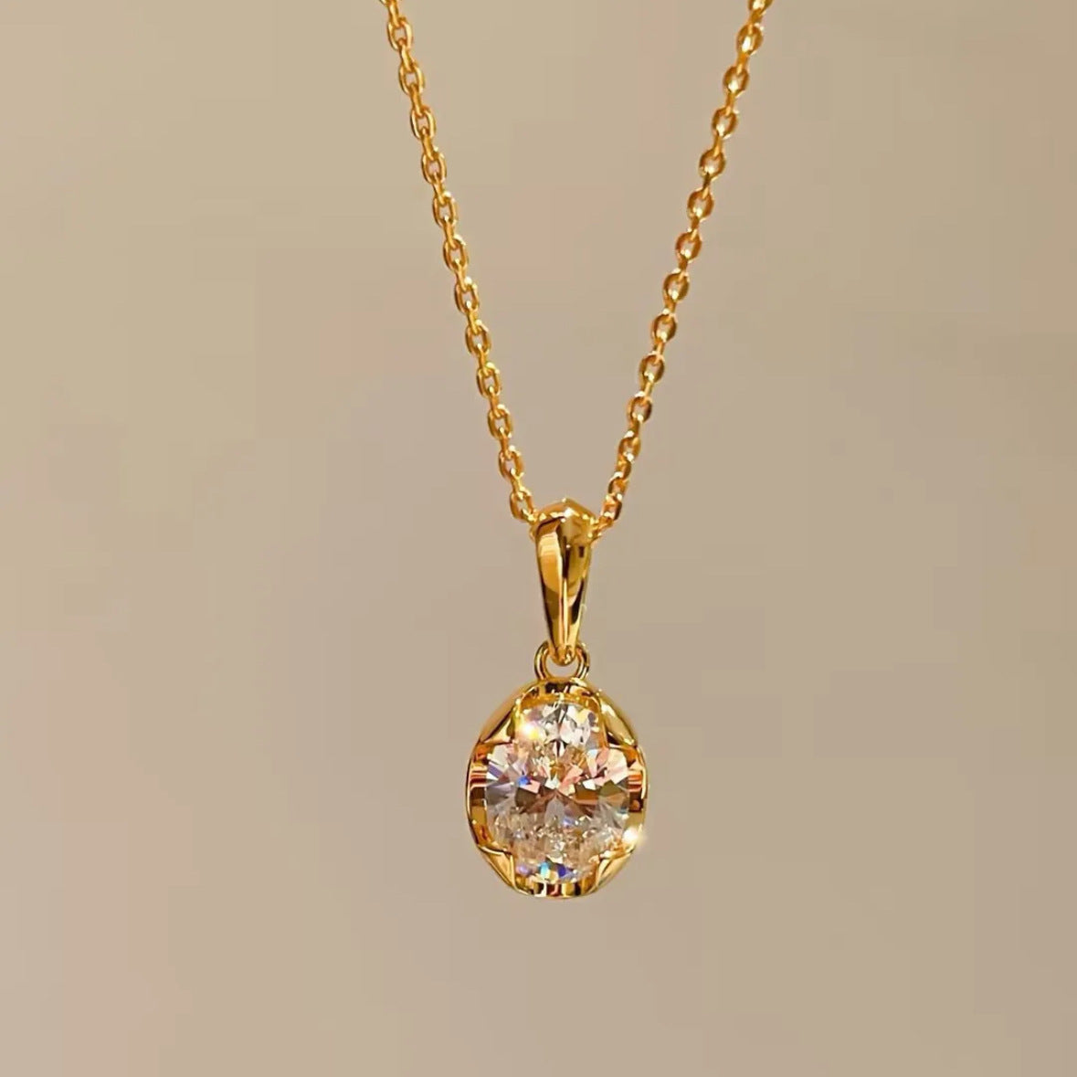 Gold necklace with a diamond pendant on a beige background
