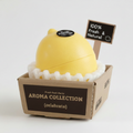 A yellow lemon-shaped gel perfume atomizer from the Fresh Fruit Puffs 'celebrate' collection, sitting in its brown cardboard packaging box with a small 'GEL SALE 100% FRESH' sign.